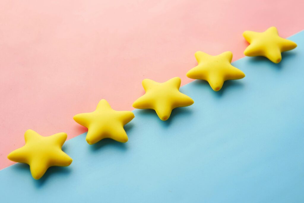 pexels-photo-9821386-9821386-1 Yellow stars on pink and blue pastel background for rating or review concept.